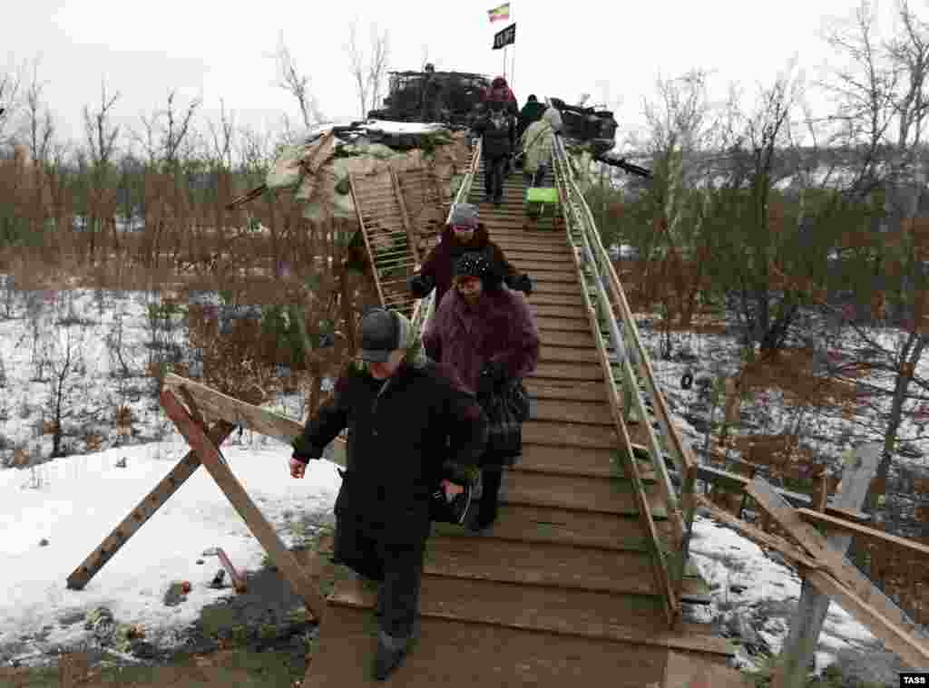 Місцеві жителі перетинають пошкоджений міст через Сіверський Донець по дорозі від КПП бойовиків до української сторони, Станиця Луганська, 25 січня 2017 року