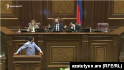 Opposition lawmaker Gevork Petrosian (at the podium) and Parliament Speaker Ararat Mirzoyan (in the center on the tribune) during a heated exchange over an initiative to ban same-sex marriages. November 12, 2019