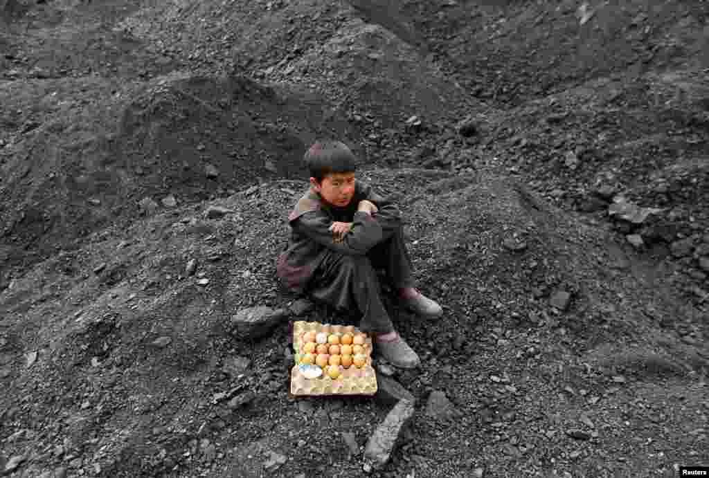 An Afghan boy selling boiled eggs waits for customers at a coal dump site on the outskirts of Kabul. (Reuters/Mohammad Ismail)