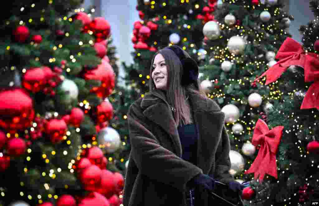 Женщина любуется рождественскими украшениями в центре Москвы 18 декабря 2025 года в преддверии Нового года и Рождества. Александра Неменова / AFP