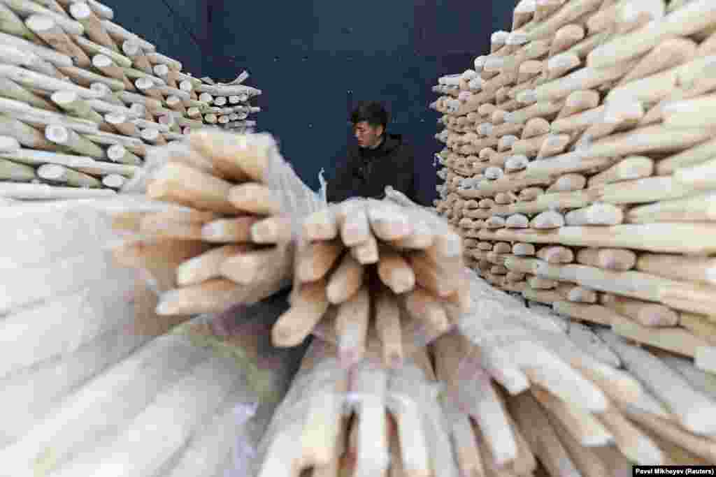 A volunteer stacks the wooden latticework that will form the walls of yurts. This distinctive aid shipment is the latest from a crowdfunded campaign by Nation&#39;s Future, a Kazakh activist group that began raising funds for Ukraine immediately after the Kremlin launched its invasion in February 2022.&nbsp;