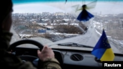 Un militar ucrainean conduce o mașină pe unul dintre drumurile de acces din Bahmut, regiunea Donețk, Ucraina, 2 februarie 2023.