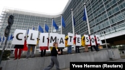 Anëtarë të organizatave ambientaliste, gjatë një proteste para selisë së BE-së në Bruksel, ku kërkuan mbrojtje më të mirë të ambientit.