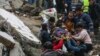 Banorët dhe ekipet e shpëtimit duke bartur me barelë një person që kishte mbetur i bllokuar nën rrënojat e një ndërtese të rrëzuar në Adana të Turqisë më 6 shkurt 2023.
