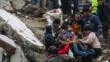 Banorët dhe ekipet e shpëtimit duke bartur me barelë një person që kishte mbetur i bllokuar nën rrënojat e një ndërtese të rrëzuar në Adana të Turqisë më 6 shkurt 2023.
