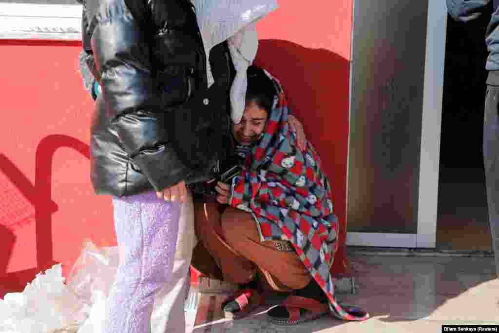 Женщина плачет на выходе из спортивной арены, где сложены тела жертв землетрясения. Кахраманмараш, Турция