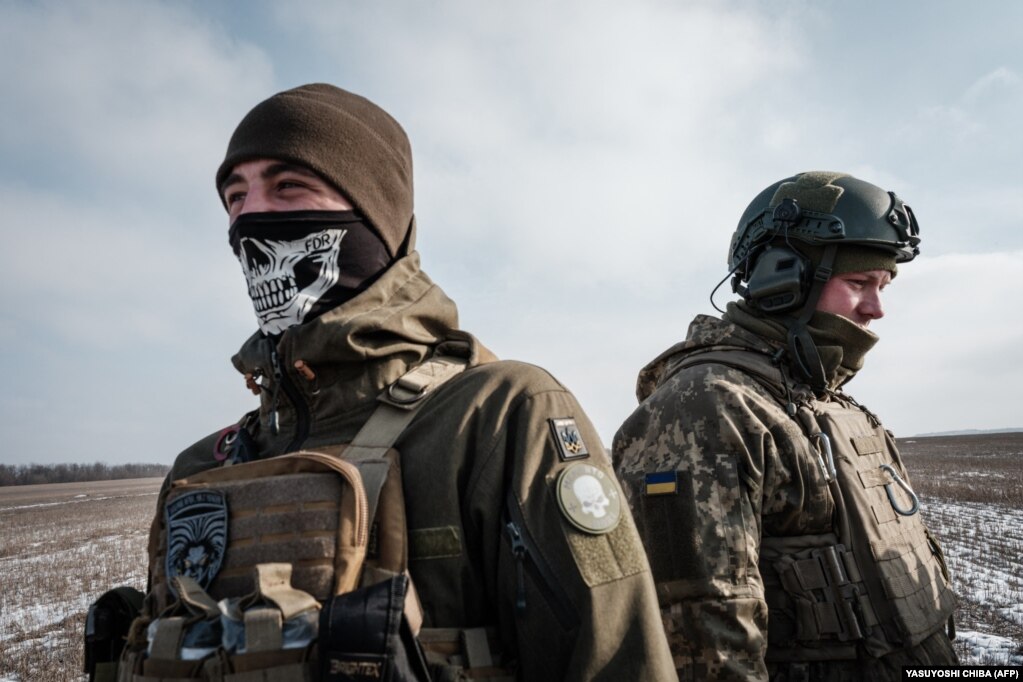 Ushtarët ukrainas nga një njësi artilerie qëndrojnë pranë qytetit të vijës së parë të frontit në Bahmut më 7 shkurt.