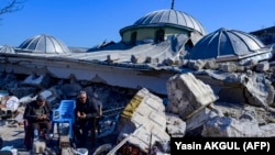 Жители рядом с руинами разрушенной мечети в Хатае (Турция), 10 февраля 2023 года