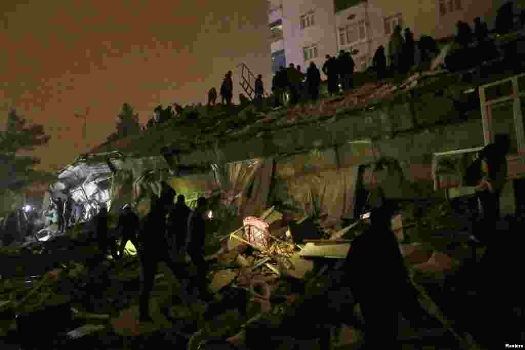 در این تصویر دیده می شود که مردم در دیاربکر ترکیه تلاش دارند تا افراد گیرمانده در زیر آوار را نجات دهند