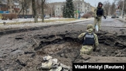 Police inspect a crater near a site of a residential building destroyed by a Russian missile strike in Kramatorsk on February 2.