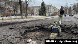 Police inspect a crater near a site of a residential building destroyed by a Russian missile strike in Kramatorsk on February 2.