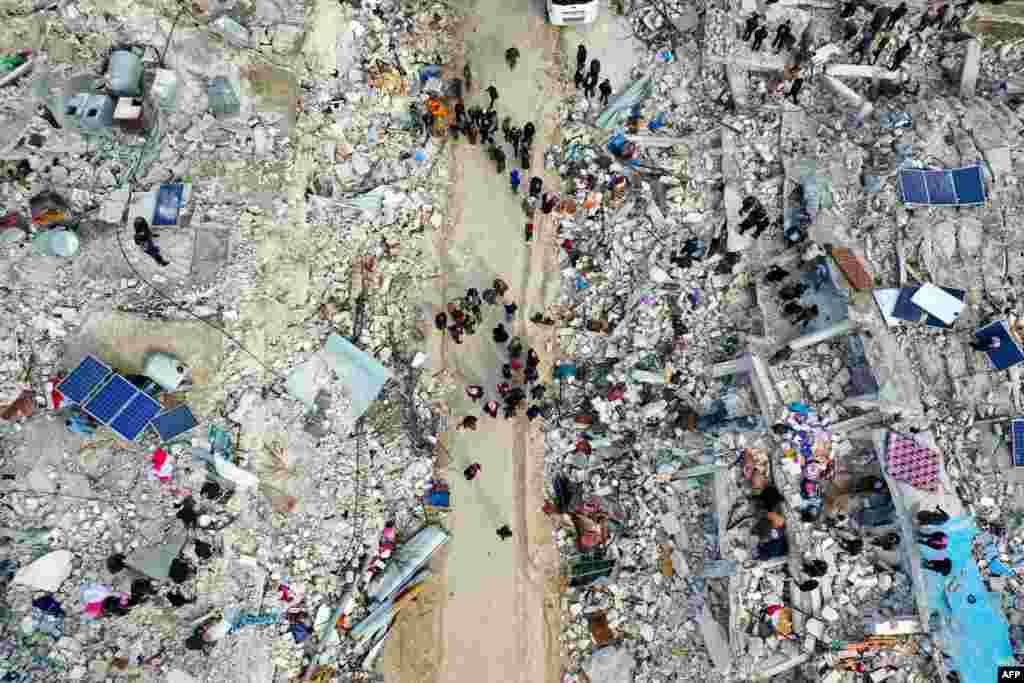 На цьому знімку зробленому з дрону видно, як жителі шукають жертв і тих, хто вижив, серед уламків будівель, які залишилися після землетрусу в селі Беснія, Сирія&nbsp;