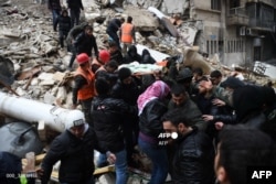 Salvatorii sirieni scot o femeie rănită de sub dărmăturile unei clădiri distruse de cutremur în Aleppo (Siria).