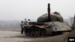 نیروهای افغان در کنار تانکی که در نزدیکی قندهار به دست طالبان منهدم شده بود.