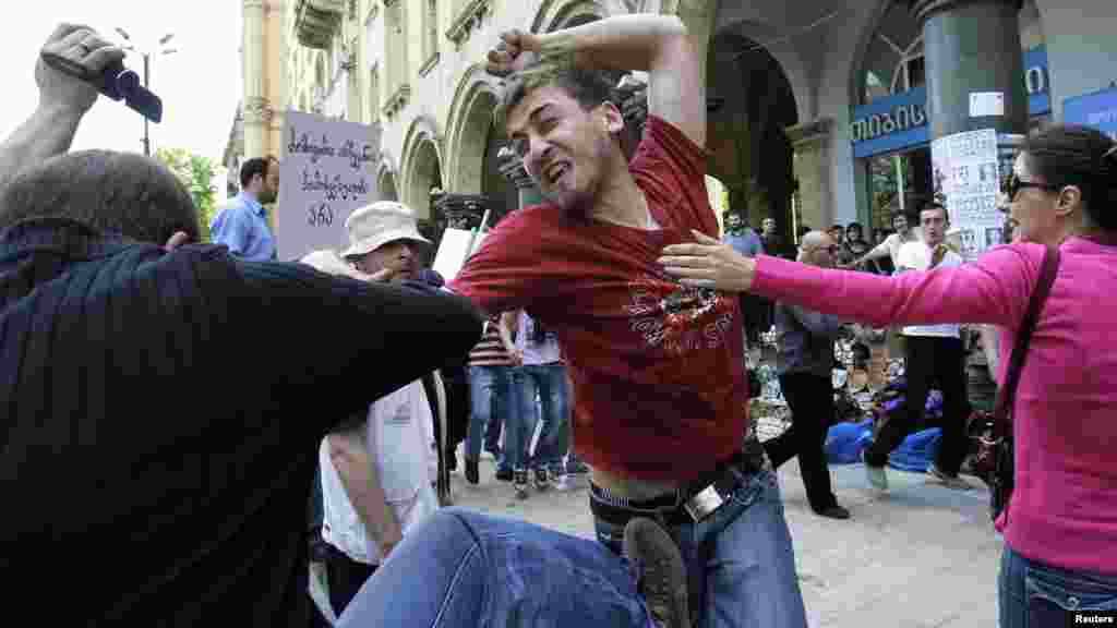 A gay rights activist (right) clashes with an Orthodox Christian activist in Tbilisi during the rally