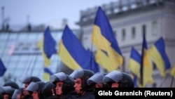 Riot police stand guard during a rally to support EU integration in central Kyiv on November 22.