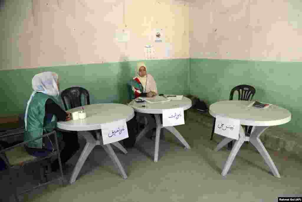 Afghan employees of the Independent Election Commission (IEC) wait to register residents at a voter registration center for the upcoming presidential election in Kabul. (AP/Rahmat Gul)