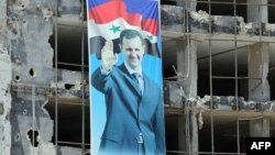 Портрет президента Башара Асада на одном из разрушенных зданий в Хомсе