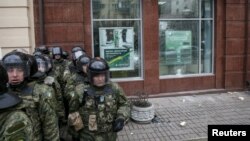 Ukrainian Interior Ministry troops stand guard outside a branch of Russian bank Sberbank, which was attacked on February 20.