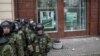 Ukrainian Interior Ministry troops stand guard outside a branch of Russian bank Sberbank, which was attacked on February 20.