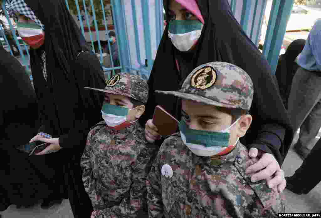 Иранка и ее дети в форме служащих Корпуса стражей исламской революции на избирательном участке. Женщины пришла проголосовать на президентских выборах 18 июня 2021 года&nbsp;