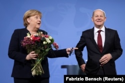 Former German Chancellor Angela Merkel (left) and current incumbent Olaf Scholz (file photo)