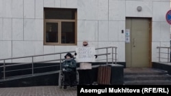 15 тәулікке қамалған белсенді Болатбек Біләловтің әйелі Ақмарал Біләлова қызымен бірге пикетке шығып тұр. Нұр-Сұлтан, 13 желтоқсан 2021 жыл 