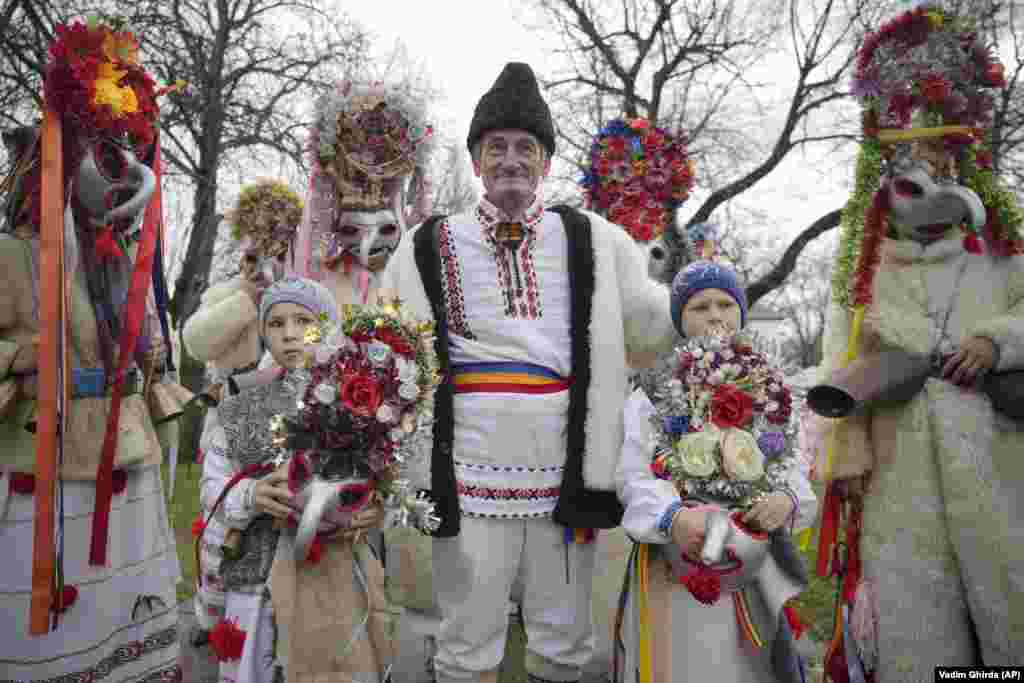 People wearing masks and costumes wait before performing in a show of winter traditions at the Village Museum in Bucharest.&nbsp;In pre-Christian rural traditions, dancers wearing colored costumes or animal furs toured from house to house in villages singing and dancing to ward off evil.