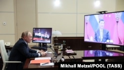 Președintele rus Vladimir Putin în biroul său din Novo Ogariovo, în timpul unei întâlniri video cu președintele Chinei, Xi Jinping 