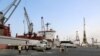 A crane unloads food aid provided by UNICEF from a cargo ship at the Red Sea port of Hodeida on January 27, 2018. Hodeida is a key entry point for United Nations aid to war-torn Yemen. / AFP PHOTO / ABDO HYDER