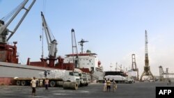 A crane unloads food aid provided by UNICEF from a cargo ship at the Red Sea port of Hodeida on January 27, 2018. Hodeida is a key entry point for United Nations aid to war-torn Yemen. / AFP PHOTO / ABDO HYDER