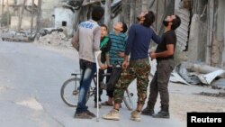 Hələbdə insanlar bombardmanı gözləyirlər.