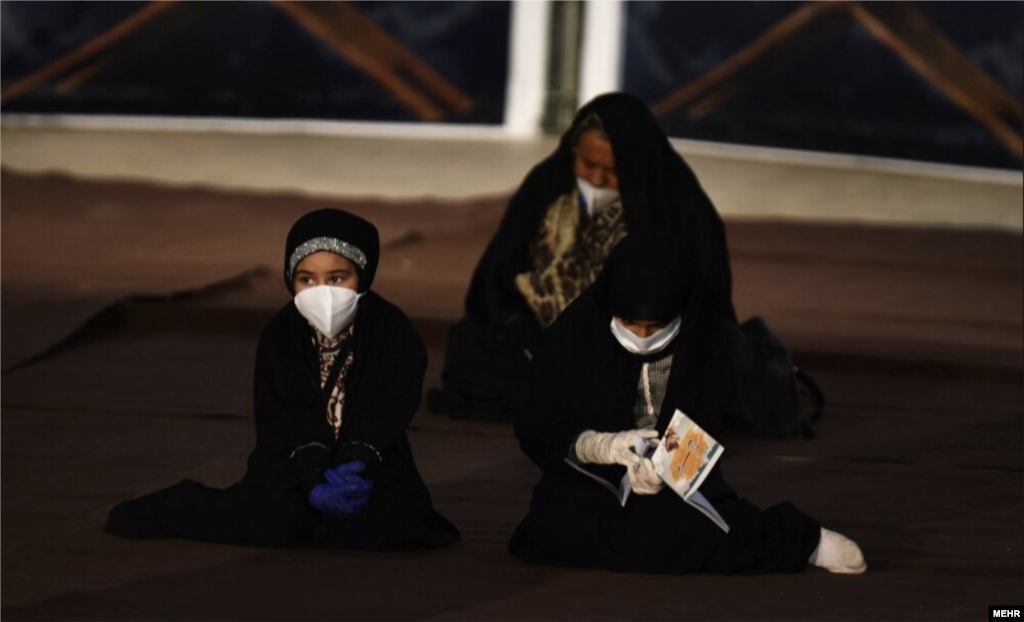 A woman and children wear face masks amid prayers in the Iranian city of Abadan.