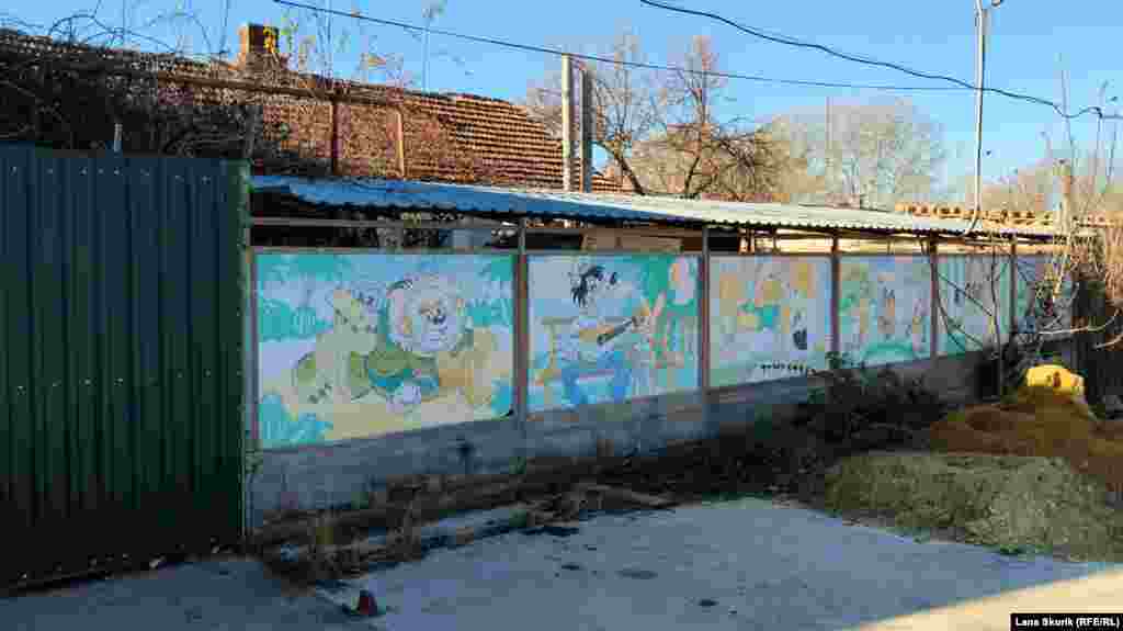 Герои советских мультфильмов изображены на заборе сельского дома