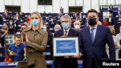 Leonid Volkov (right) poses with Aleksei Navalny's daughter Daria Navalnaya (left) and European Parliament President David Sassoli during the award ceremony for the Sakharov Prize at the European Parliament in Strasbourg, France, on December 15, 2021.