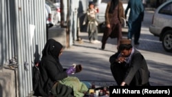 حمیده احمدی یکی از آموزگاران زن در افغانستان که کارش را از دست داده و حالا روی جاده بوت پالش میکند