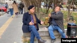 Анди Гарсия (вляво) слуша уличен музикант, изпълняващ мелодия от филма "Кръстникът". София, 8 декември 2021 г.