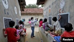 A járvány miatt bezáratott iskola diákjainak szabadtéren tartanak órát a kelet-indiai Dzsoba Attpara településen 2021. szeptember 13-án