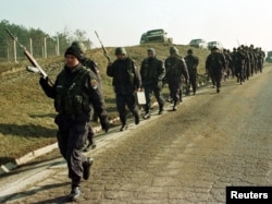 Serbian policemen move into position on January 18 in Racak.