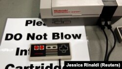 Знак, приклеенный к старой системе Nintendo, гласит: «Пожалуйста, не дуйте в картриджи».