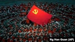 Артисты в костюмах спасателей собираются вокруг флага Коммунистической партии во время гала-шоу в преддверии 100-летия основания Коммунистической партии Китая. Пекин, 28 июня 2021 года