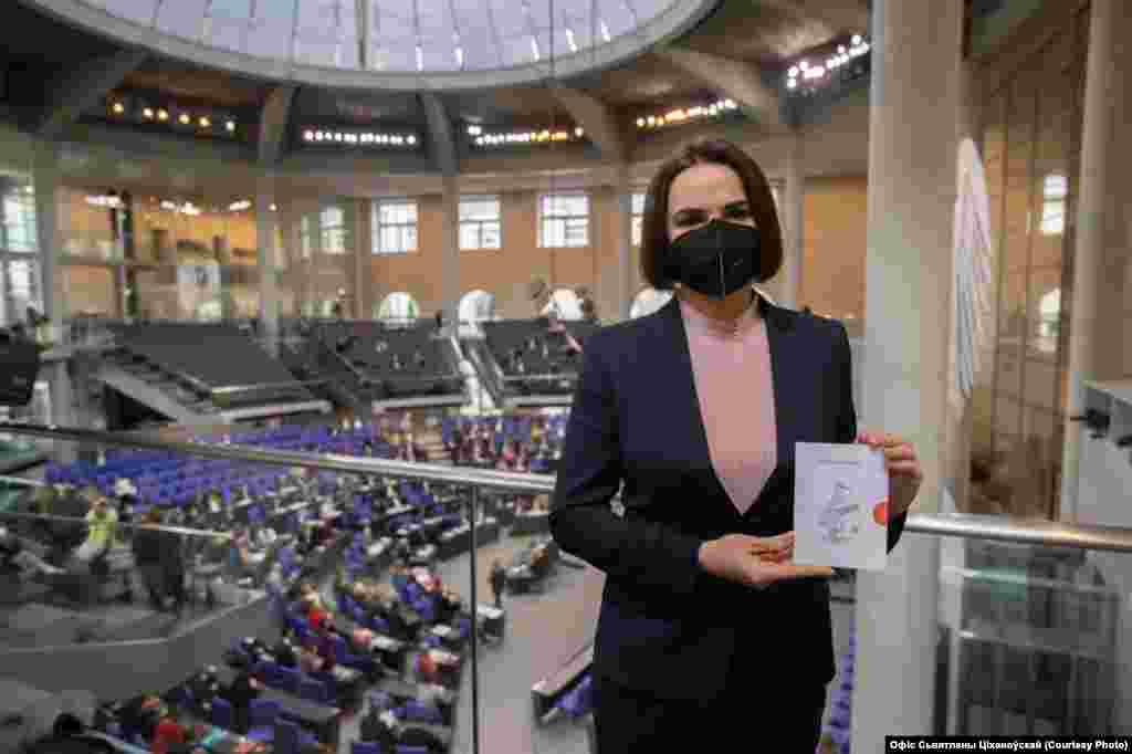 Exiled opposition leader Svyatlana Tsikhanouskaya shows a postcard from the Free Postcards project at Germany&#39;s Reichstag in Berlin.