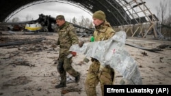 Ukrainian sappers carry a Russian military drone at the Antonov airport in Hostomel on the outskirts of Kyiv on April 18.
