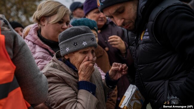 Жена реагира емоционално на храната, раздавана като хуманитарна помощ в Херсон, 17 ноември 2022 г.