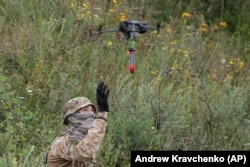 Доброволец в украинската армия и дрон със закачен екслозив.