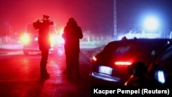 Members of the media stand near a police blockade after explosions rocked the Polish village of Przewodow near the border with Ukraine on November 15. 