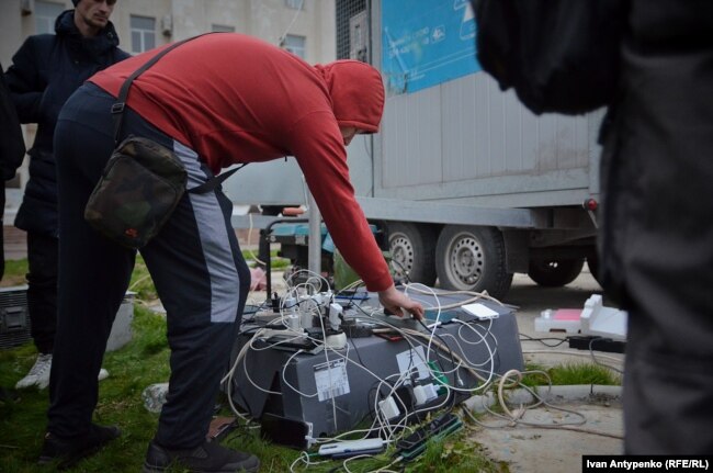 Деокупований Херсон без мобільного звʼязку, люди заряджають гаджети, листопад 2022 року