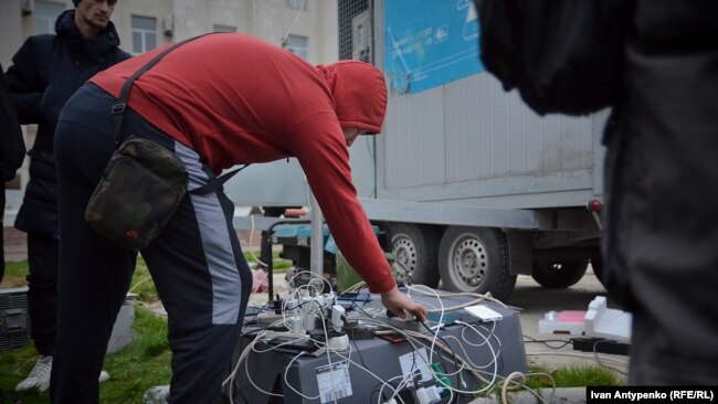 Мобилна станция за зареждане на телефони в Херсон, 16 ноември 2022 г. Ден по-късно са издигнати и отоплени шатри, в които хората могат да си зарееждат техниката или да се обадят на близките си.