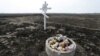 Toys are placed near a cross in memory of victims of the Malaysia Airlines Flight 17 plane crash in the village of Rozsypne in Ukraine's eastern Donetsk region in March 2020.