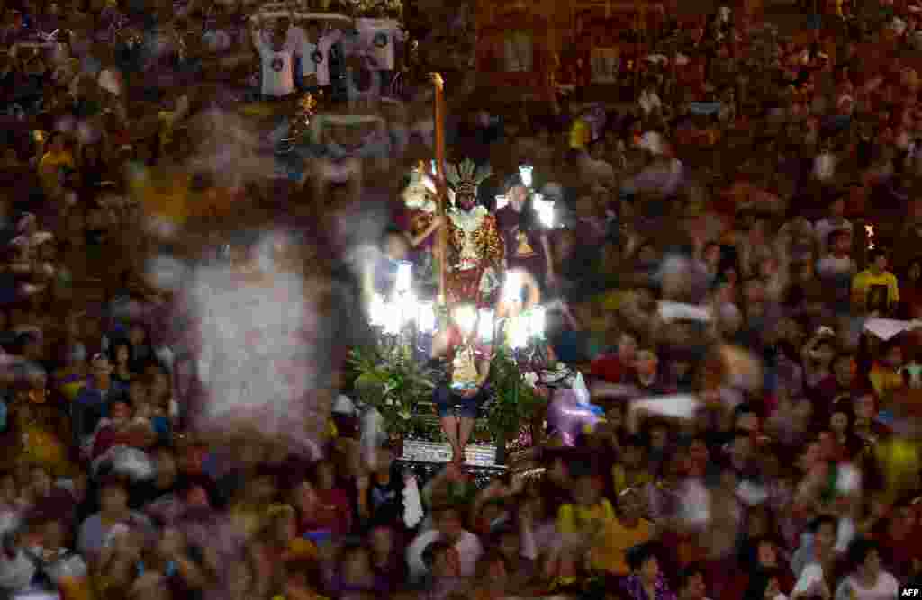 A replica of the Black Nazarene is paraded during a procession in Manila. Millions of barefoot devotees packed the streets of the Philippine capital for one of the world&#39;s biggest Catholic parades, honoring a statue of Jesus Christ they believe has miraculous powers. (AFP/Noel Celis)